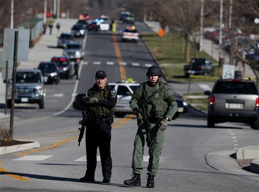 Police officers block a road on the Virginia Tech campus in Blacksburg, Va., after a gunman killed a police officer and another person Thursday, Dec. 8, 2011. The school said a police officer pulled someone over for a traffic stop and was shot and killed. The shooter ran toward a nearby parking lot, where a second person was found dead.