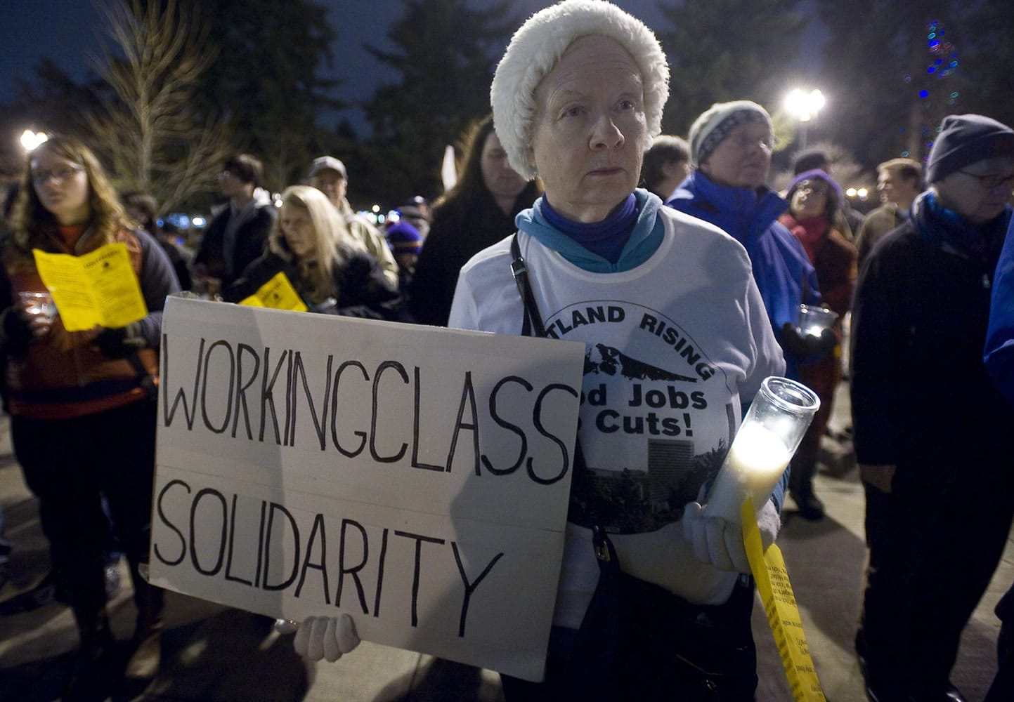 Jobs with Justice member Jane McAlonan, of Vancouver, stands in solidarity with workers from The Hilton Vancouver Washington during a candlelight vigil between the hotel and City Hall on Tuesday.