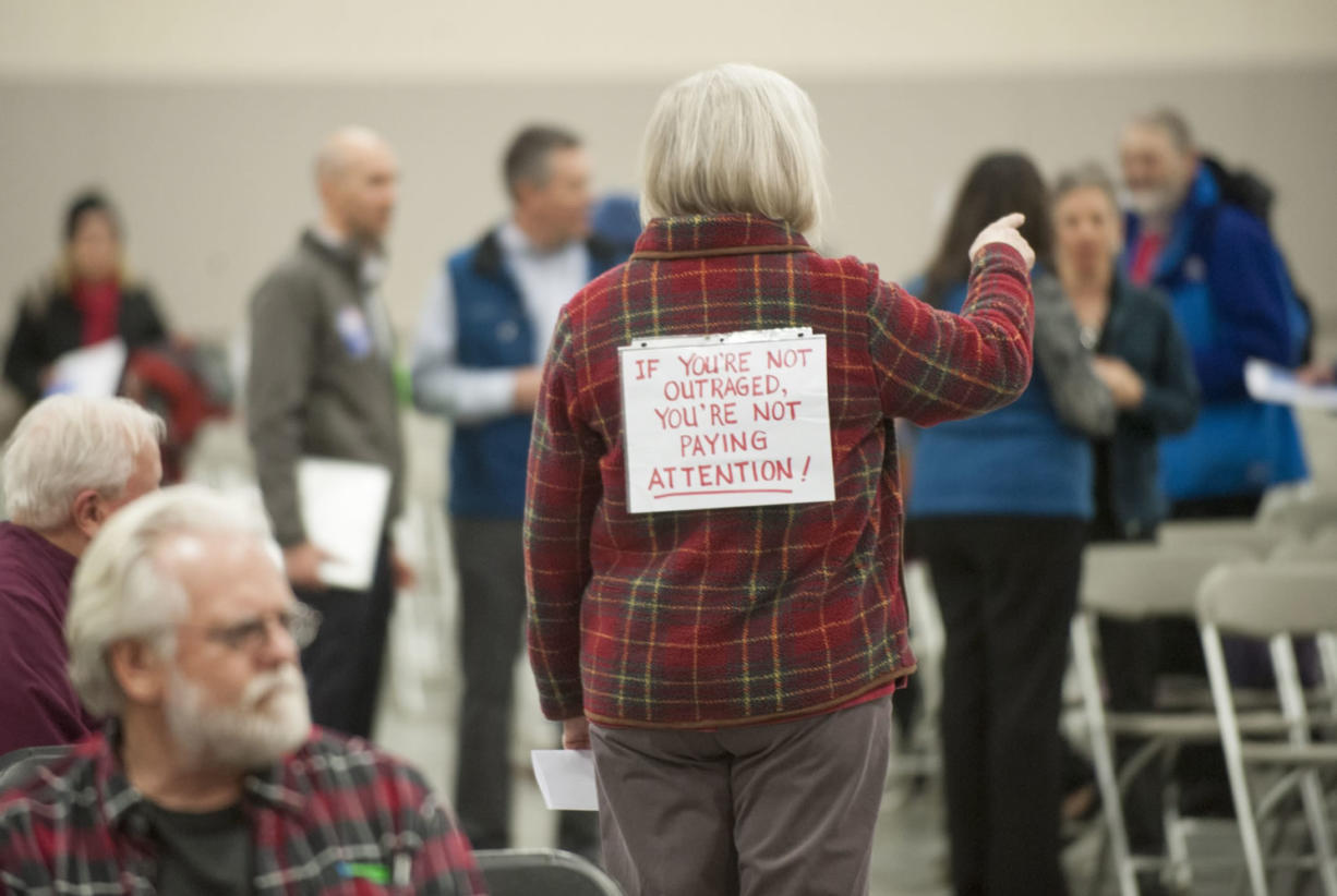 Edie Cotton wore a sign on her back opposing the proposed Vancouver Energy oil-by-rail terminal during a hearing at the Clark County Event Center at the Fairgrounds on Tuesday. The Energy Facility Site Evaluation Council is taking comment on the project until Jan. 22 as it finalizes an environmental review and prepares a recommendation for the governor.