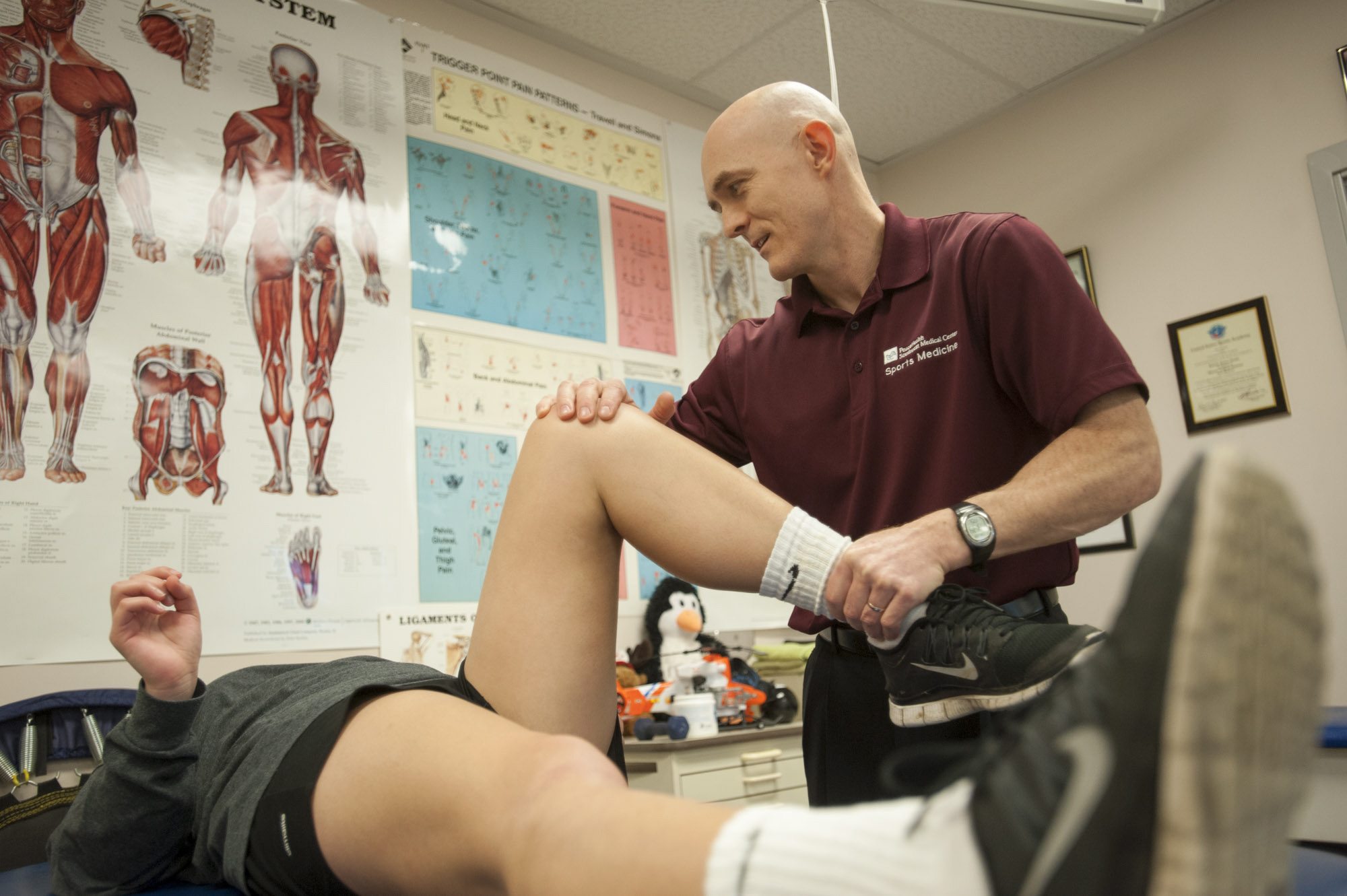 Dr. Kevin deWeber examines the knee of an injured soccer player Thursday at Clark College&#039;s O&#039;Connell Sports Complex. DeWeber is a sports medicine physician and, this summer, will be the medical director of the High Performance Center at the Rio 2016 Olympics.