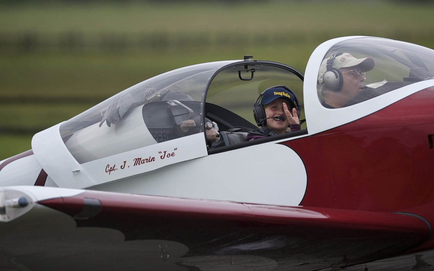 Jule Sugnet, 10, of Portland, waves to her mother and brother as Tom Sampson taxis his experimental home-built RV-7 airplane after taking the youngster for a ride during Pearson Air Museum's Open Cockpit Day on Saturday.
