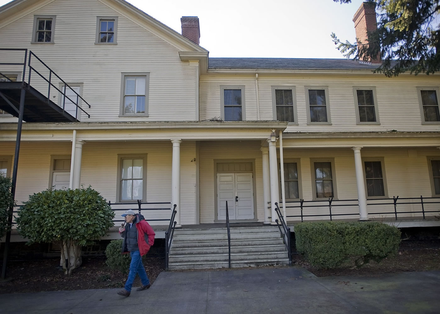 Historical architect and consultant Fred Walters walks past an East Barracks building Monday.