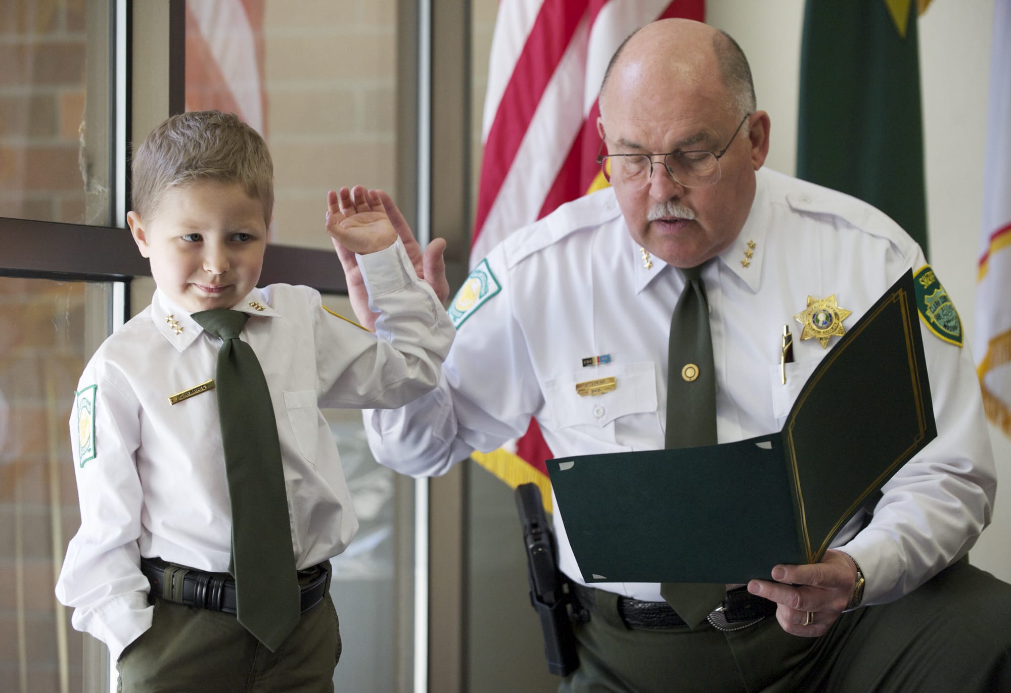 Carter Harris, 4, takes the oath of office from Clark County Sheriff Garry Lucas as he is named sheriff for a day on Wednesday.