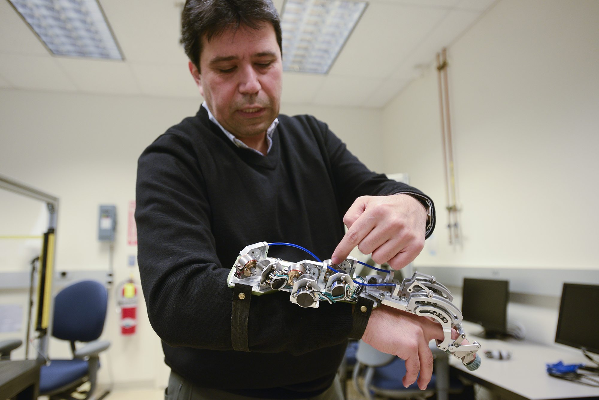 Hakan Gurocak, WSU Vancouver professor and director of the school of engineering and computer science, demonstrates technology he patented for the haptic glove on Jan. 7. The glove allows the user to experience a sense of touch in virtual reality settings.