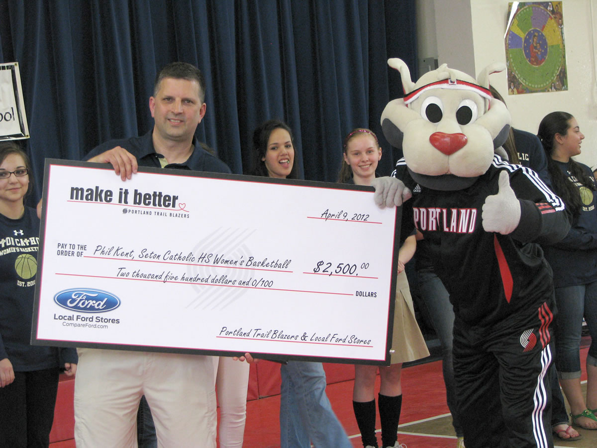 Evergreen Highlands: Northwest Ford Coach of the Year Phil Kent and Blaze, the mascot of the Portland Trail Blazers, hold a $2,500 check for Seton Catholic High Schools' girls' basketball program.