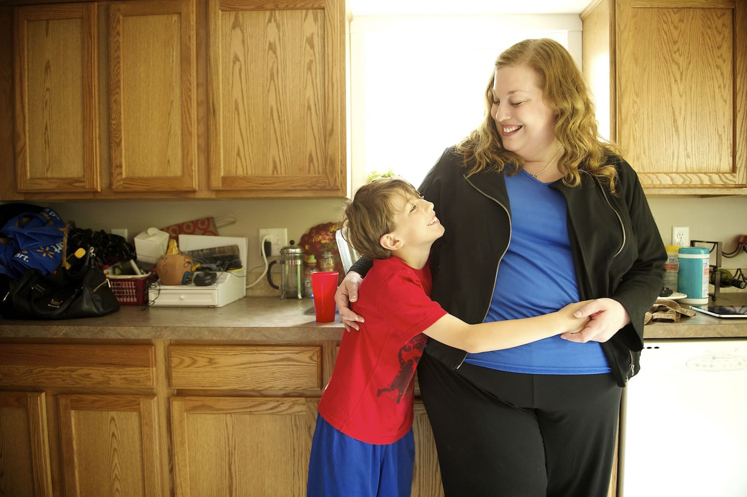 Laina Harris shares a moment with her 10-year-old son, Cameron, in the kitchen of the family's Camas home.