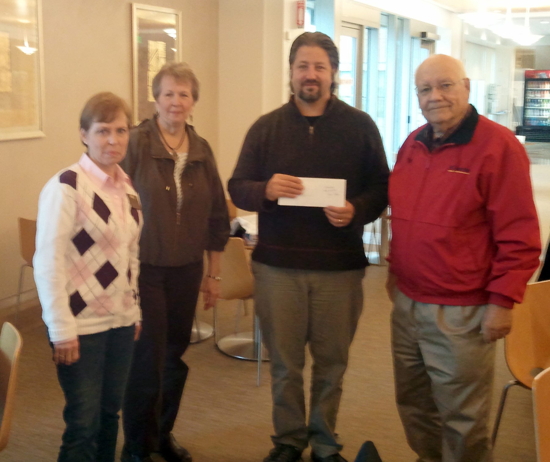 Glenwood: Winter Hospitality Overflow concert organizer Nancy Deibert, second from left, presents WHO coordinator Kevin Hiebert with a check for more than $9,400 as Darrell Brandenberg, right, and Peggy Kain look on.