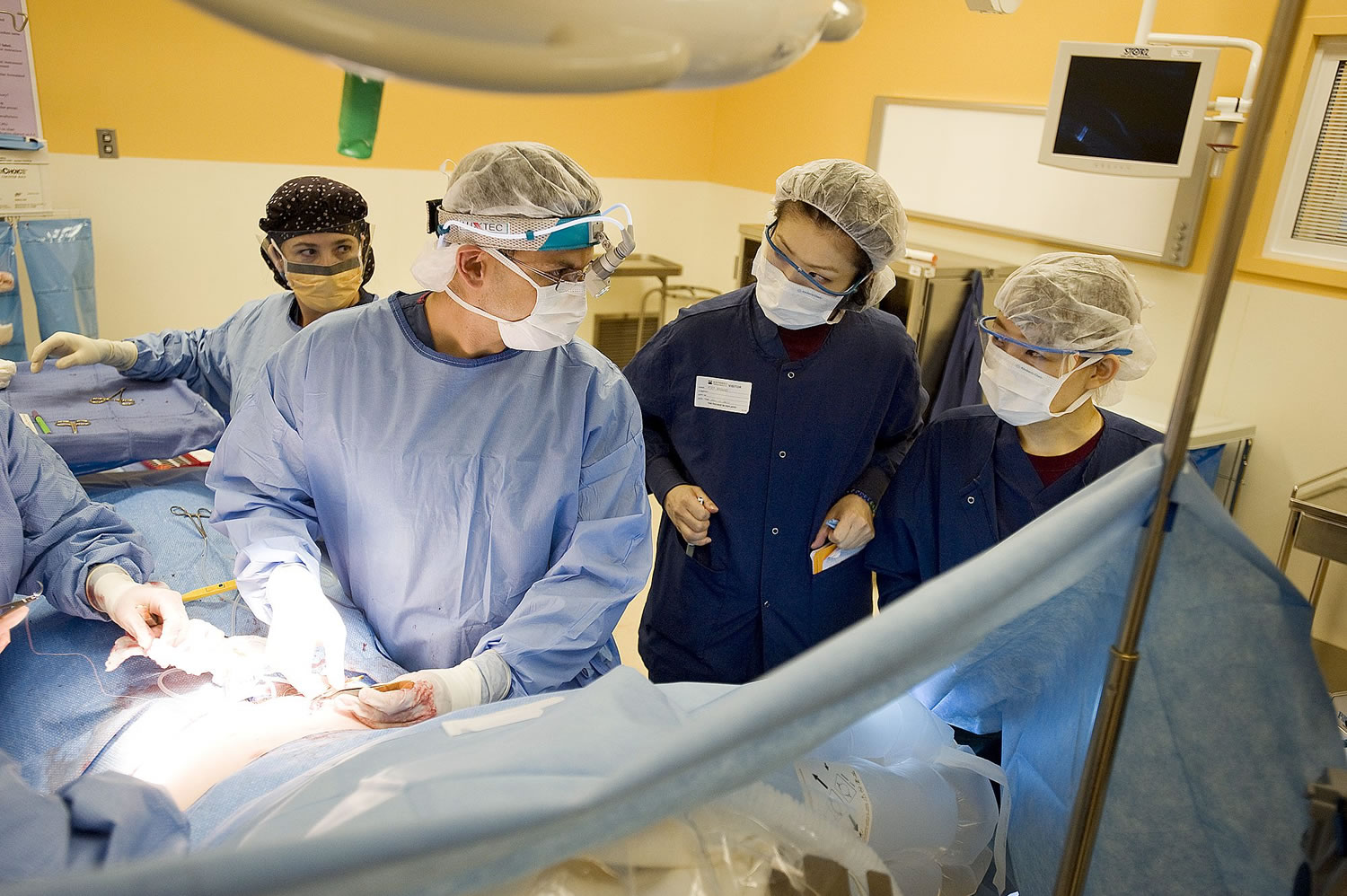 Dr. Allen Gabriel, left, explains his surgical decisions to Japanese surgeons Hiroko Taneda, right, and Mika Watanabe, center, during a panniculectomy at PeaceHealth Southwest Medical Center Wednesday.