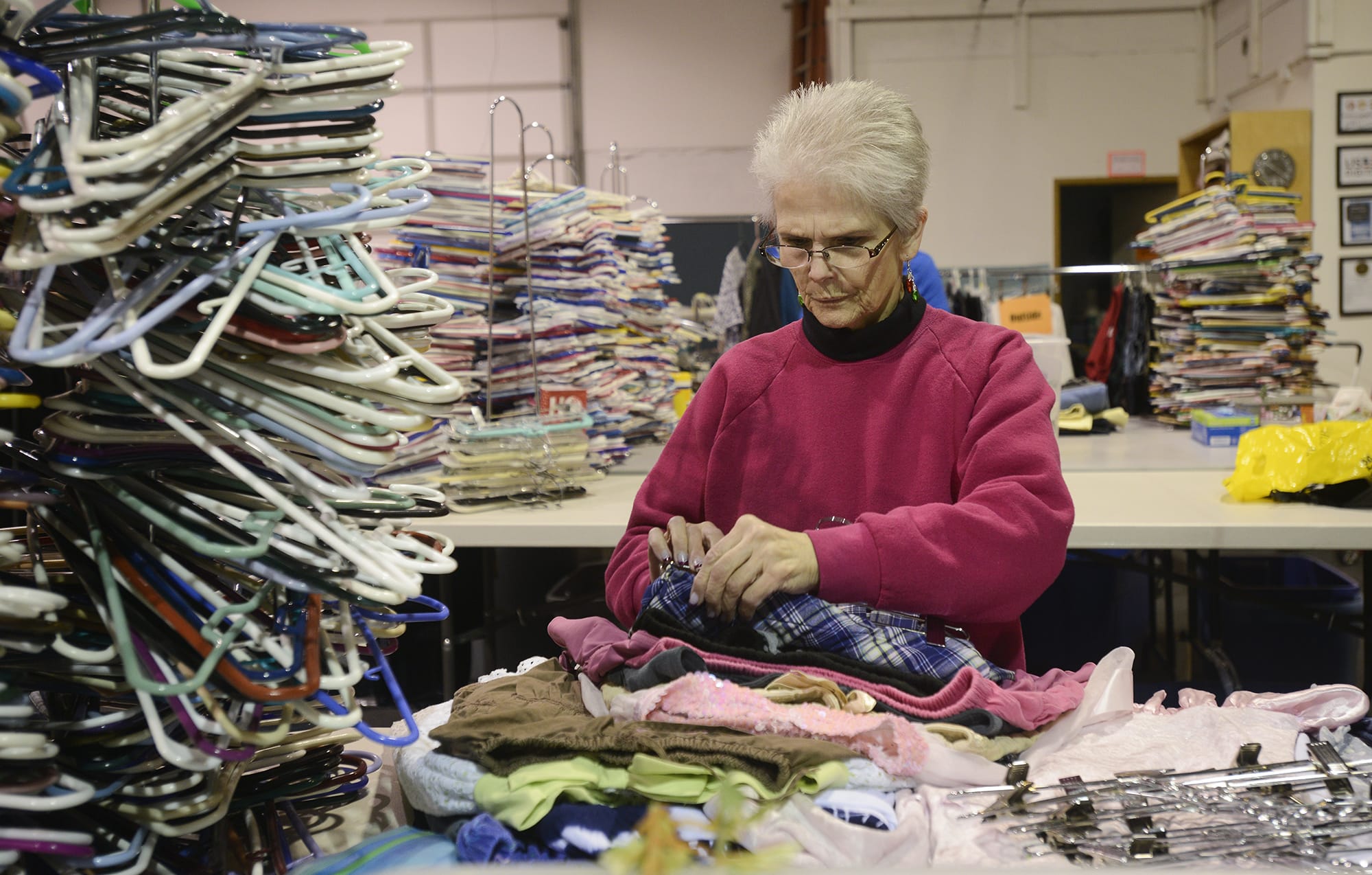 Volunteer Ann Blackwell sorts through clothing donations at the Giving Closet. The nonprofit provides free clothing, shoes, bedding, books and non-perishable food items to low-income and homeless Vancouver families.