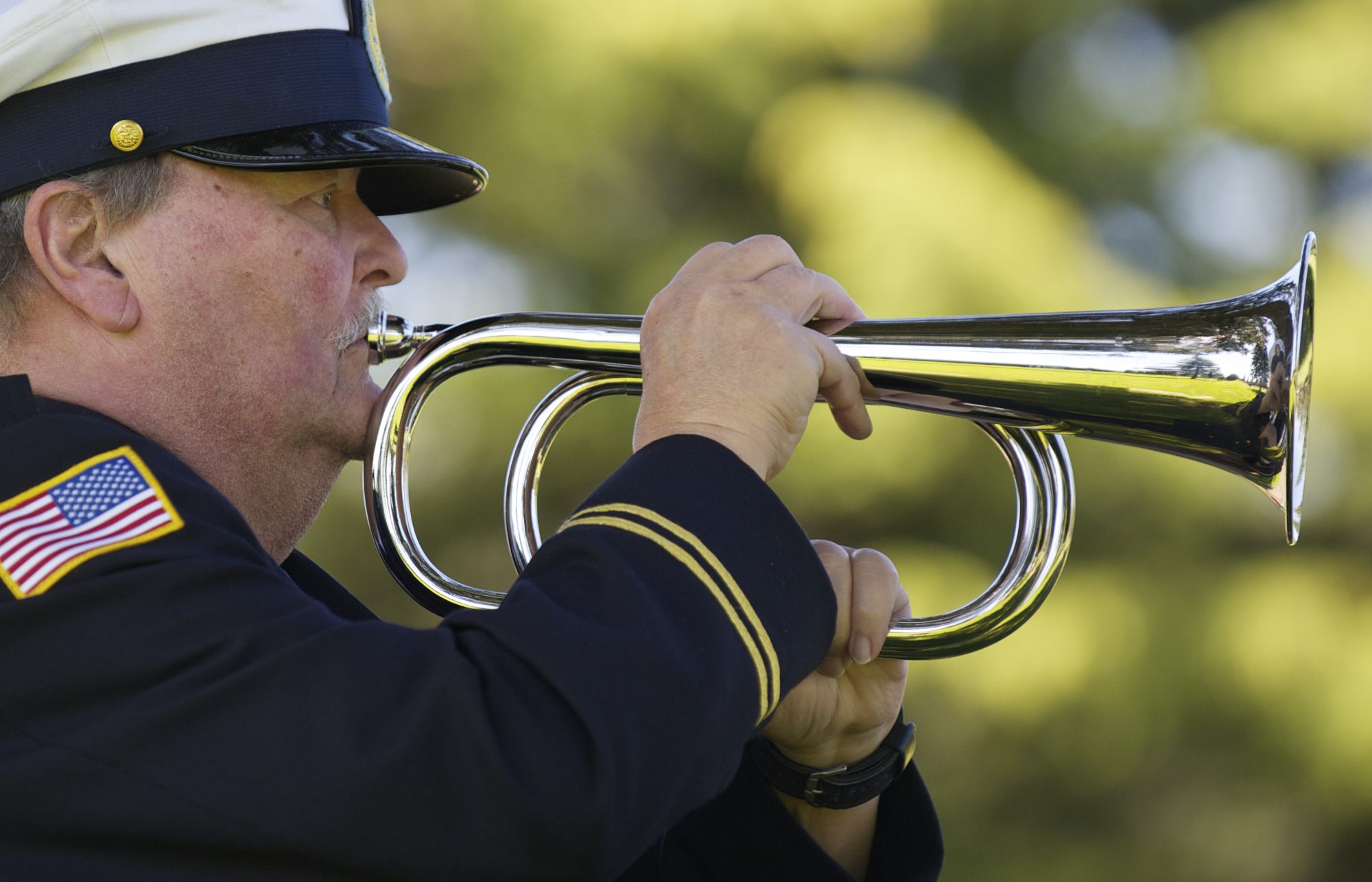 Richard Puttkamer, from American Legion Post 122, plays taps on an electronic bugle to honor veterans.