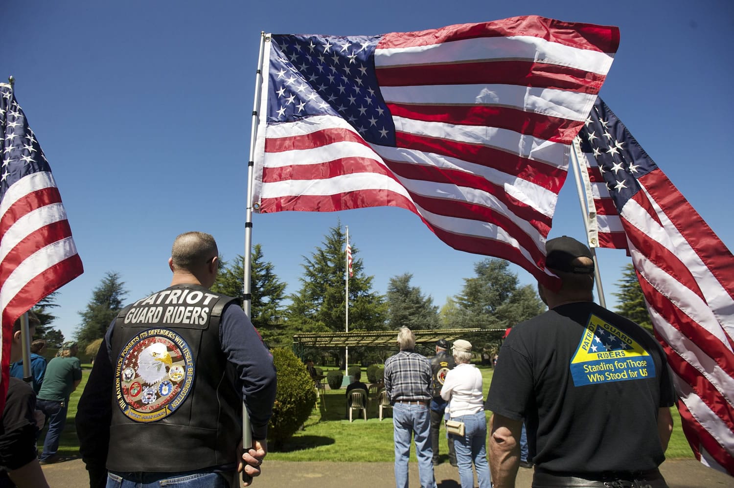 Patriot Guard riders hold flags during a memorial service for veterans that did not receive a full military funeral at Evergreen Memorial Gardens.