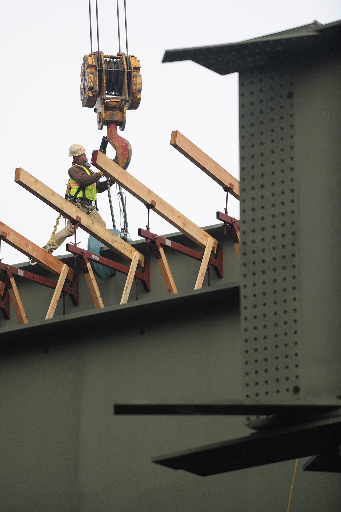 James Jacks, an ironworker with Oregon-based West Side Iron, attaches a cable to a 150-ton steel girder, preparing it for installation Thursday at the state Highway 500 and St.