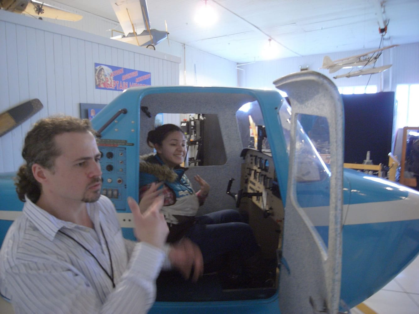 Hudsonis Bay: During a Washington School for the Deaf field trip to Pearson Air Museum, Jessica Arceo-Jimenez, seated in the Link Trainer at Pearson Air Museum, signs to senior volunteer Joshua Staley.