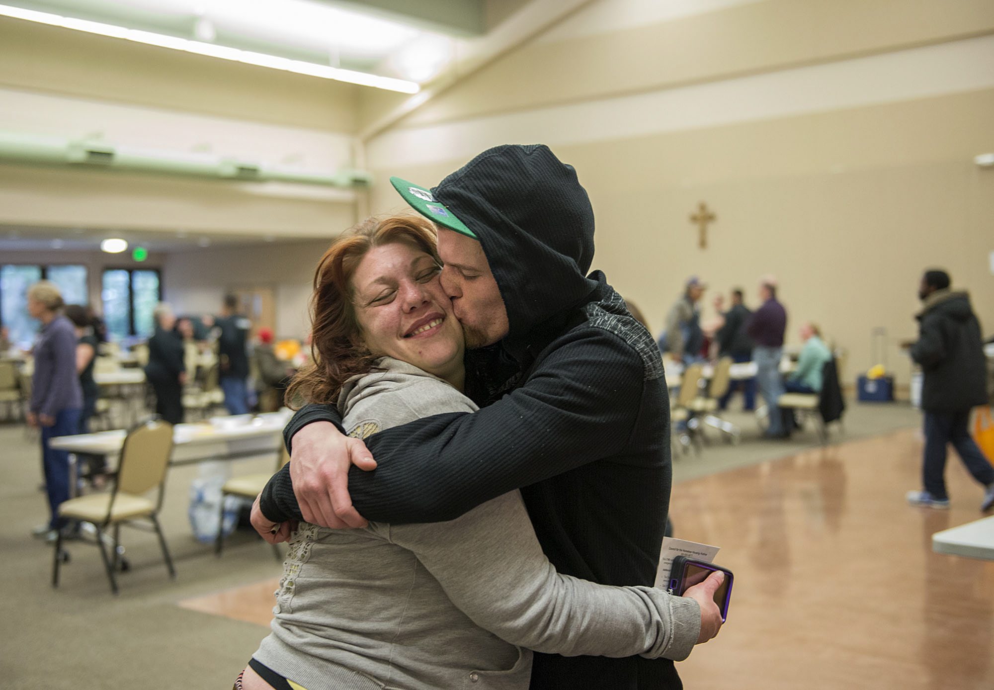 Newlyweds Miranda and J.J. Macomber of Vancouver share a sweet moment as they wait to shop for new clothes during Project Homeless Connect on Thursday morning.