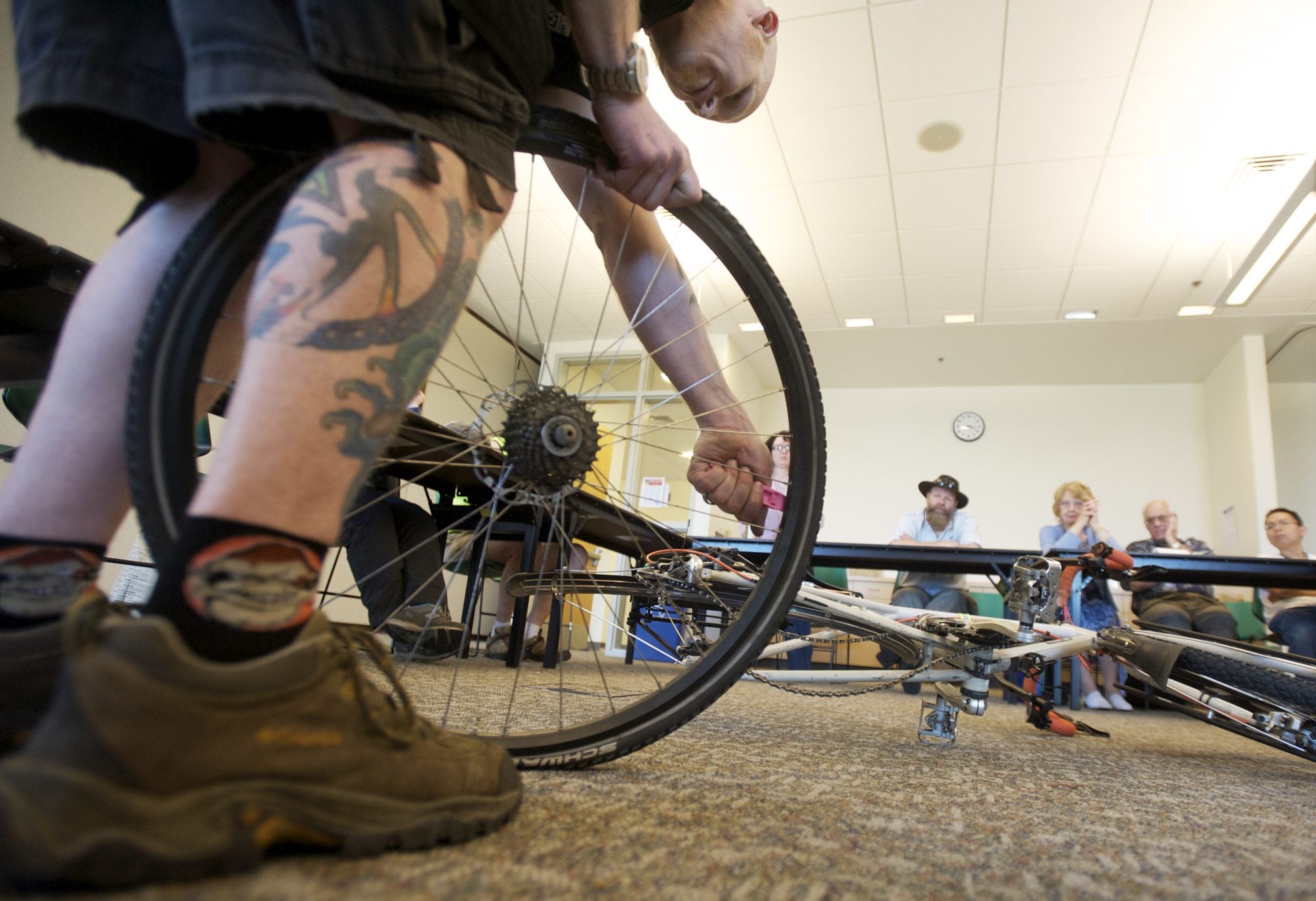 Wade Leckie of Bad Monkey Bikes, Board and Skate of Vancouver demonstrates how to fix a flat bicycle tire during a workshop at the Do-It-Yourself Fair at Clark College on Sunday.