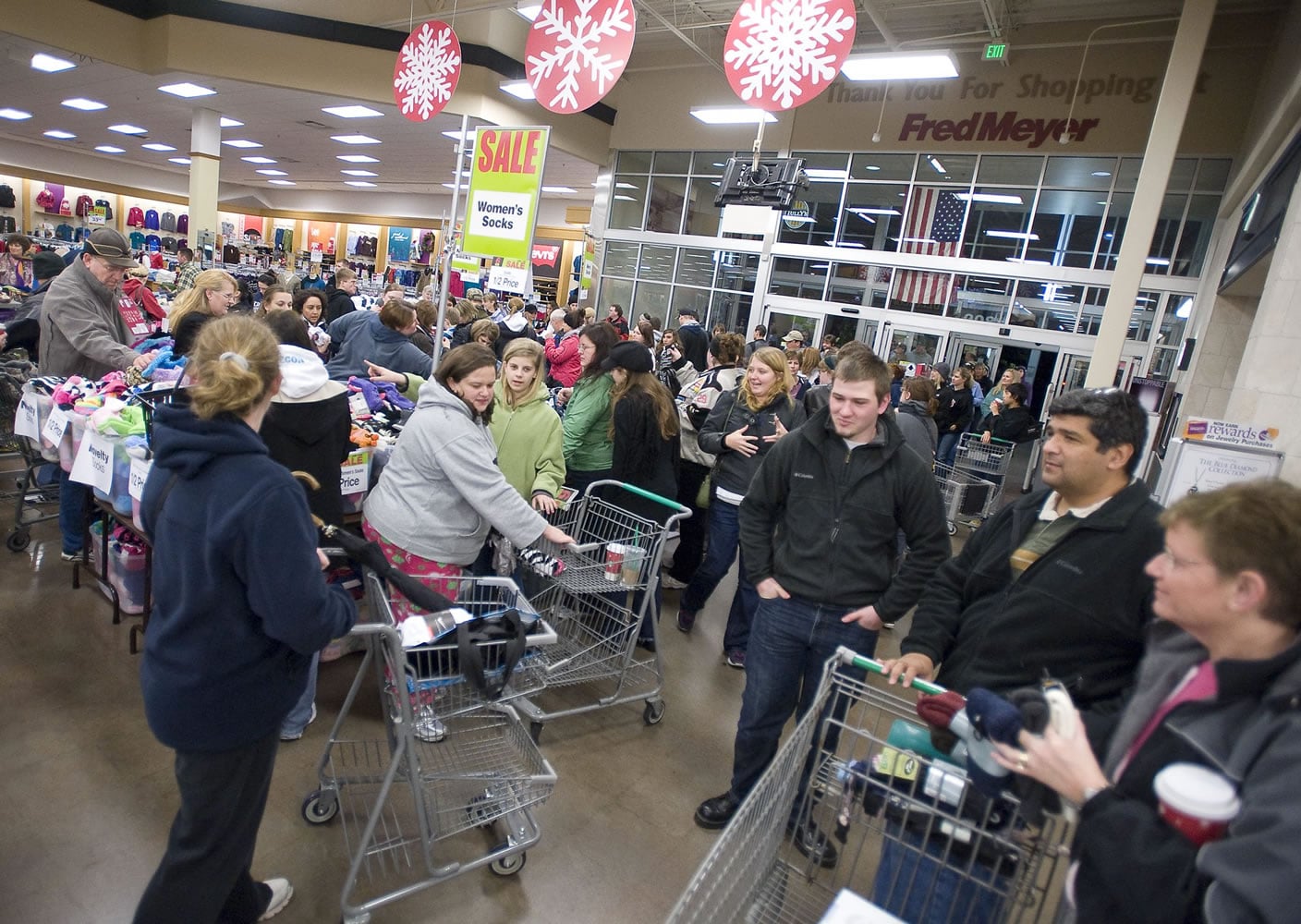A crowd swarms around the sock tables inside Fred Meyer Salmon Creek as the store opens for Black Friday specials on November 25, 2011.