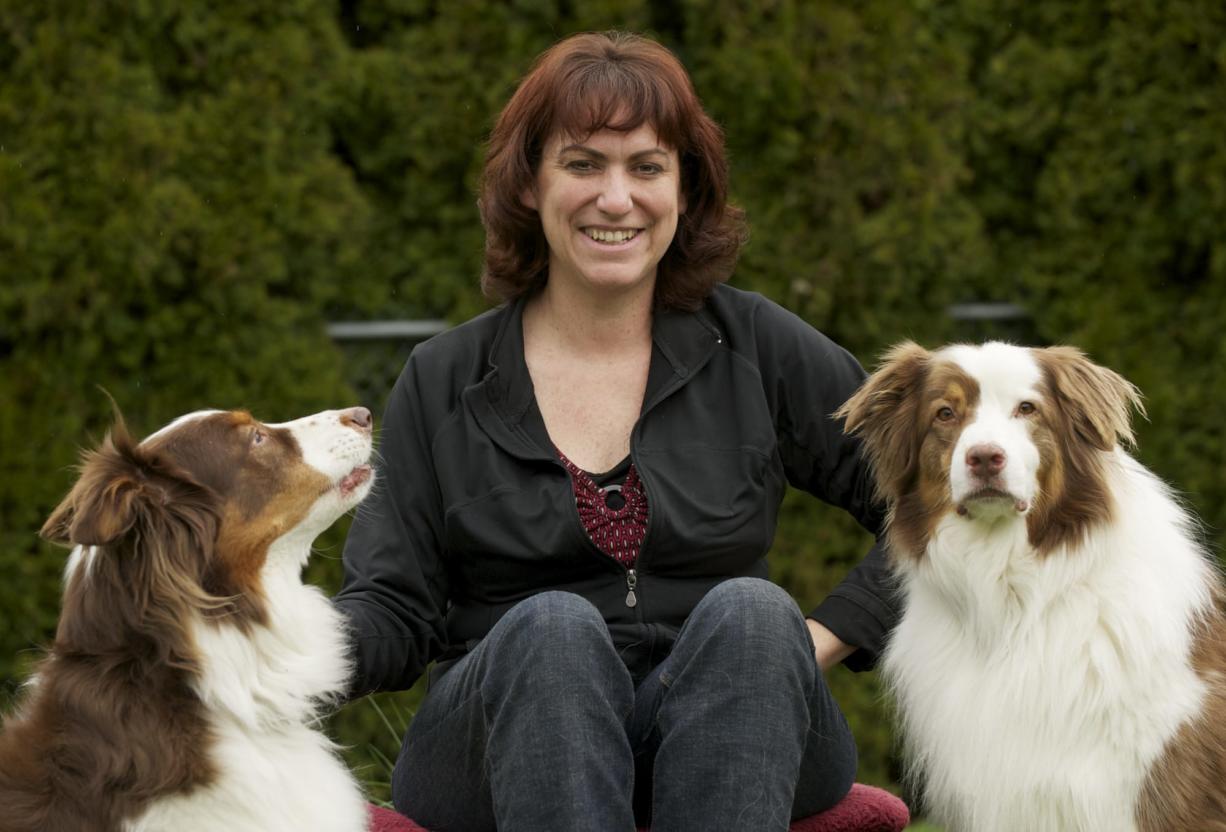 Colleen Coy, owner of Sit and Stay Pet and House Sitting Services, with her Australian shepherds Dealer, left, and River.