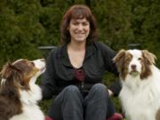 Colleen Coy, owner of Sit and Stay Pet and House Sitting Services, with her Australian shepherds Dealer, left, and River.
