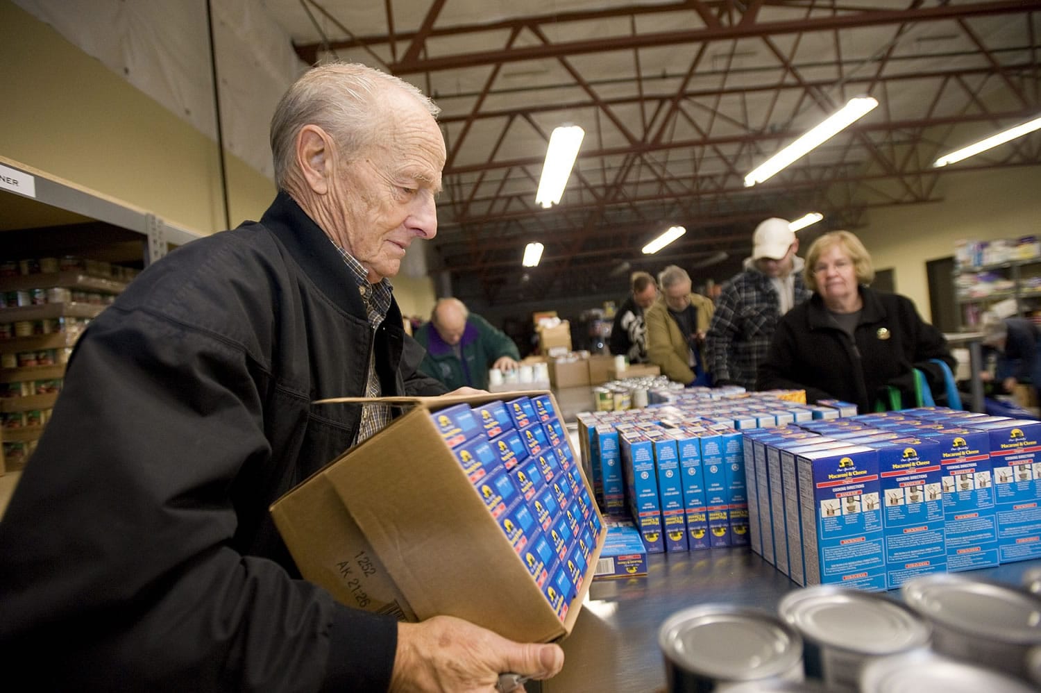 Volunteer Joe Smith, 76, stacks the mac-n-cheese that will help feed hungry kids through the Share Backpack Program.