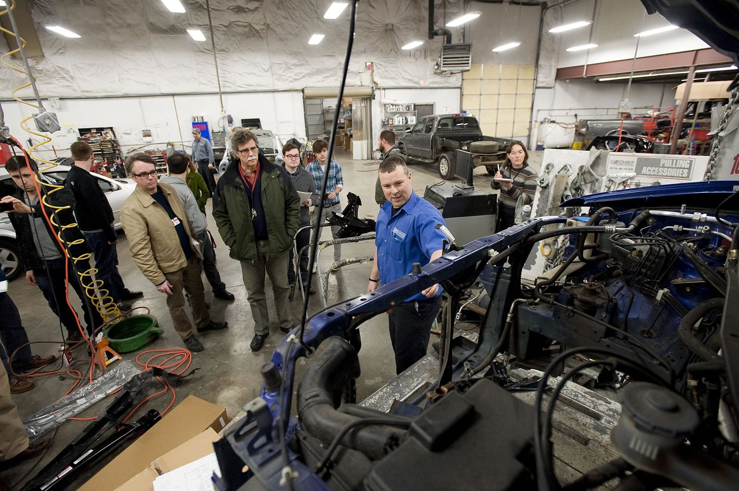 Photos by Steven Lane/The Columbian
Dick Hannah Collision Center Director Rick Stoker, center, gives a tour of the body shop to a group of Washington State University Vancouver students and OMSI representatives working on an exhibit for the Portland museum.