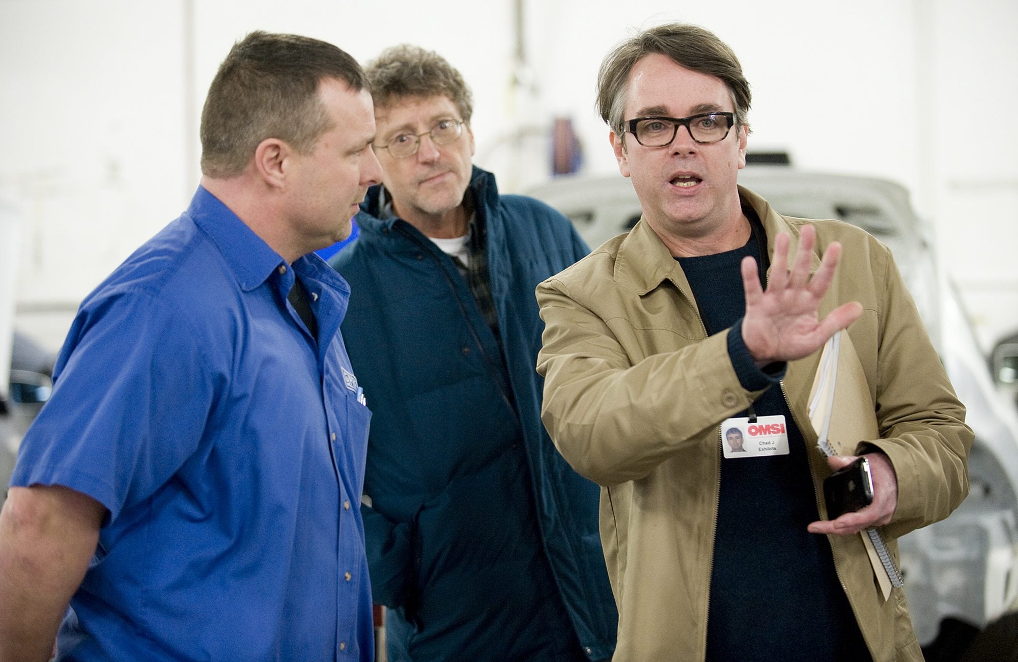 Dick Hannah Collision Center Director Rick Stoker, left, leads Oregon Museum of Science and Industry design manager Chad Jacobsen, right, and OMSI project manager Denny Andersen on a tour of the collision center to show examples of today's automobile technology.