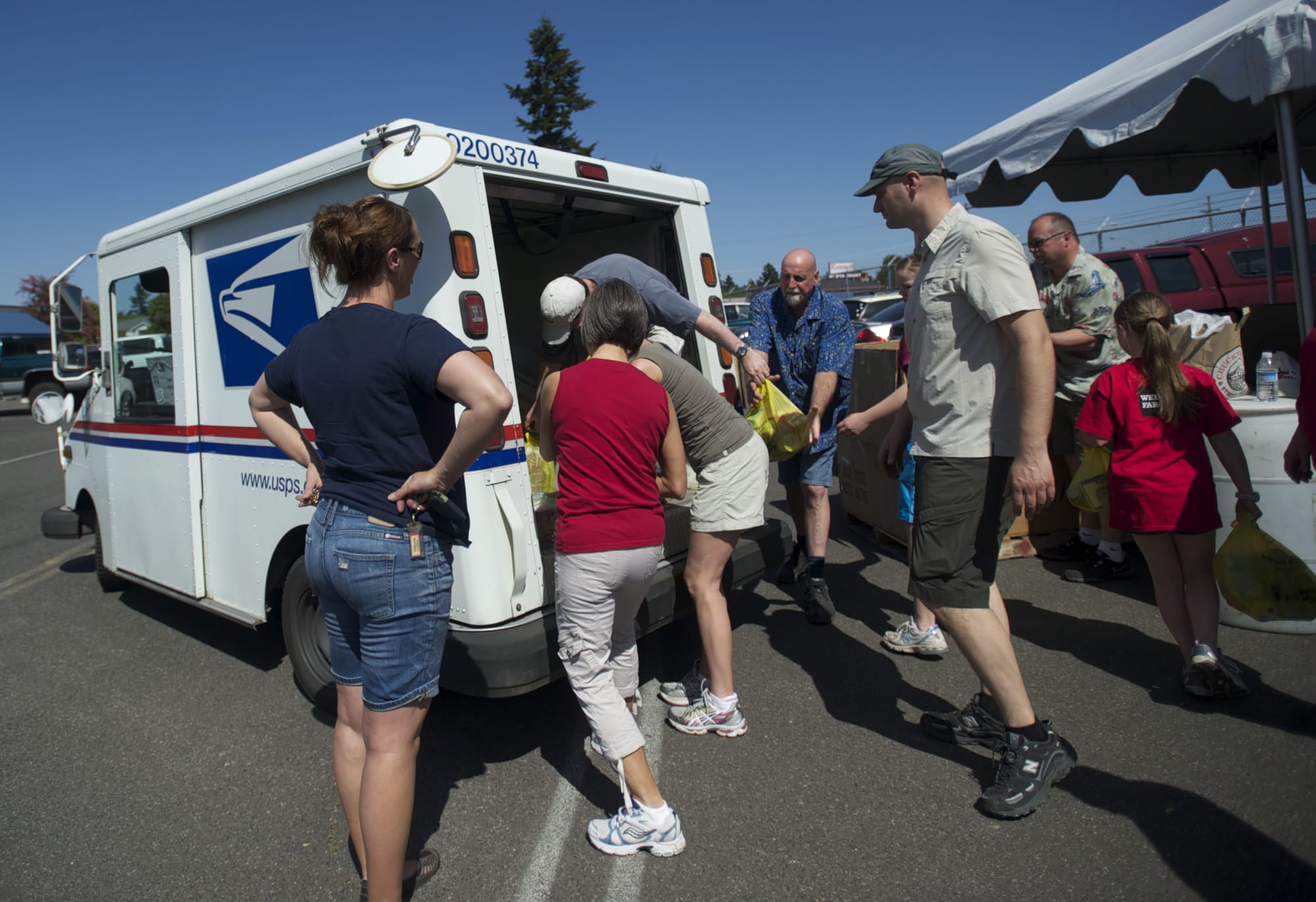 Volunteers help unload a mail truck filled with canned goods during the annual letter carriers' food drive.