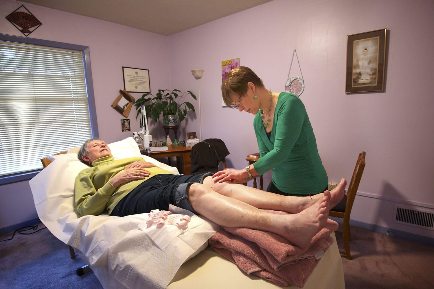 Jowanna Harman-Stever, right, of New Harmony Health in Vancouver, provides acupuncture treatment to patient Virginia Barber, 80, recently.