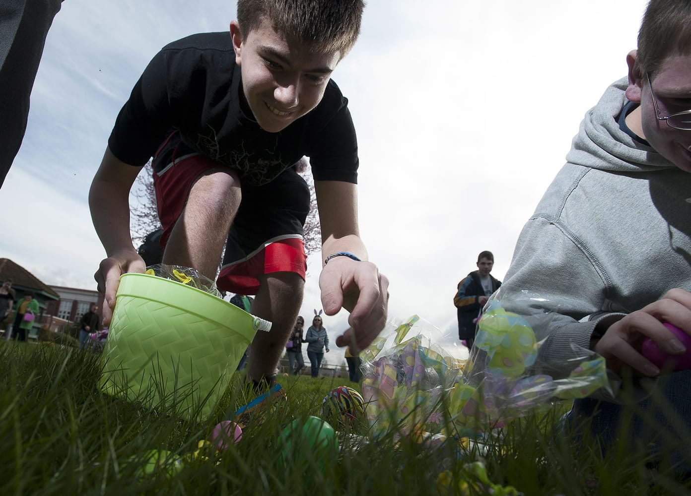 Washington State School for the Blind students (from left) Tanner Deck, 14, and Gabe Markstrom, 17, grab candy during the annual Easter egg hunt.