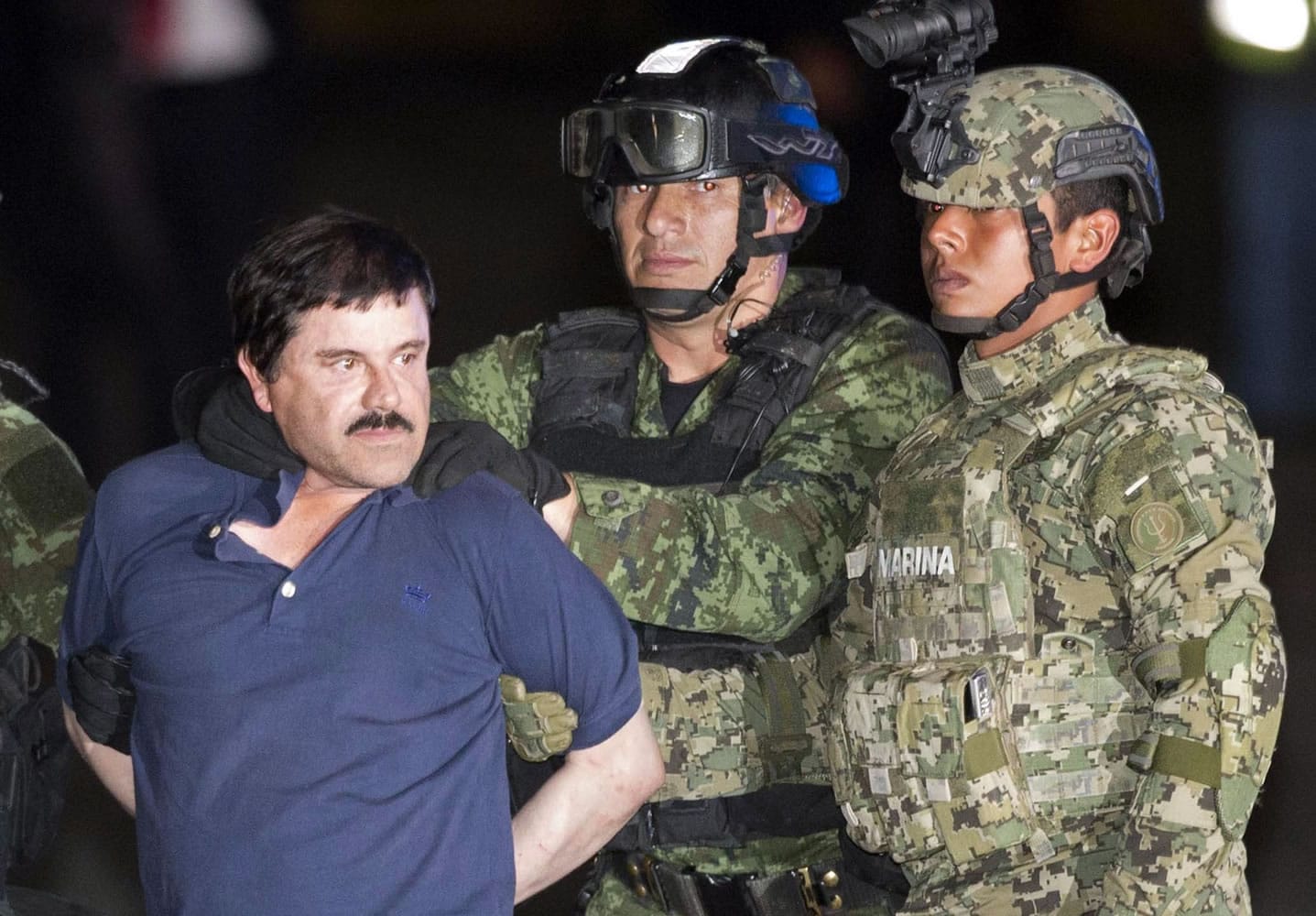 Joaquin "El Chapo" Guzman is made to face the press as he is escorted to a helicopter in handcuffs by Mexican soldiers and marines at a federal hangar in Mexico City, Mexico, Friday, Jan. 8, 2016. Mexican President Enrique Pena Nieto announced that Guzman had been recaptured six months after escaping from a maximum security prison.