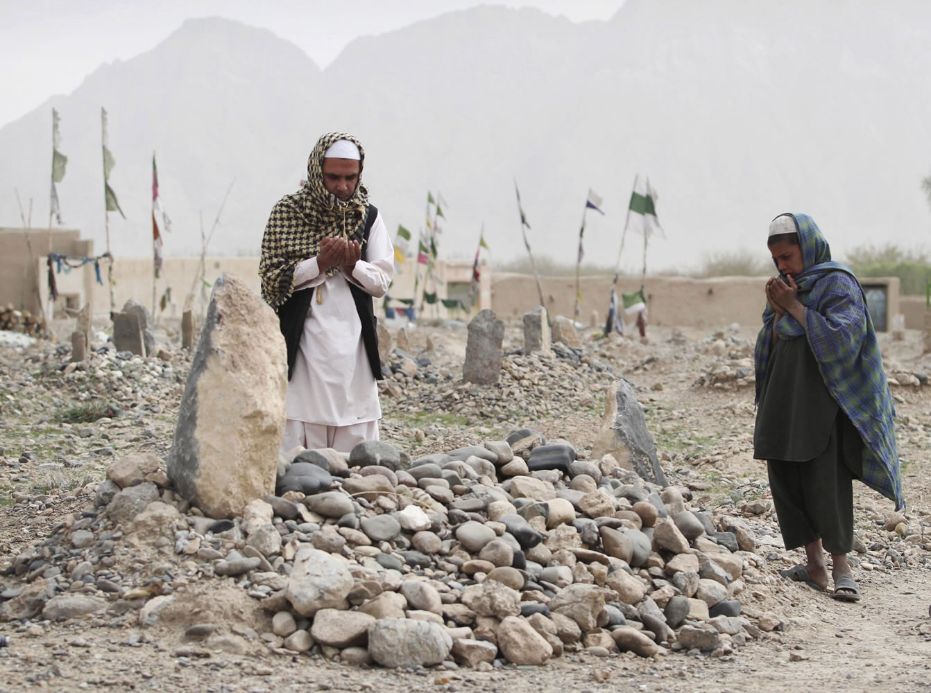 Afghan villagers pray Saturday at the grave of one of the victims killed in the March 11 shooting rampage in the Panjwai district of Kandahar province.