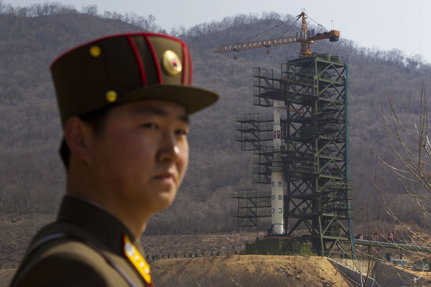 A North Korean soldier stands in front of the country's Unha-3 rocket, slated for liftoff between April 12-16, at a launching site in Tongchang-ri, North Korea on Sunday.