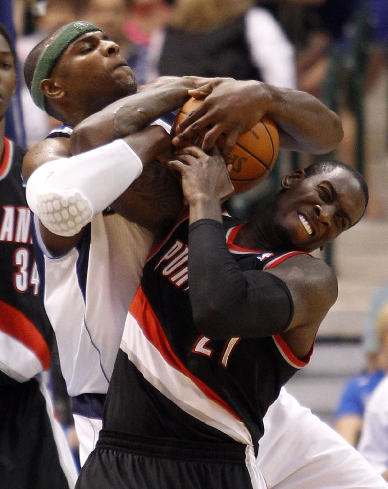 Dallas Mavericks center Brendan Haywood (33) and Portland Trail Blazers forward J.J. Hickson (21) battle for a rebound during the first half of an NBA basketball game on Friday April 6, 2012, in Dallas.