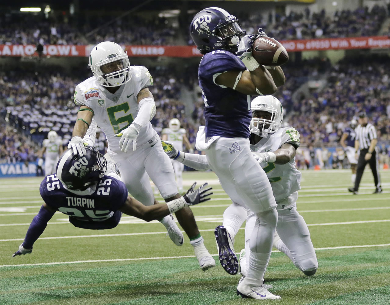 TCU wide receiver Jaelan Austin (15) catches a touchdown pass in front of Oregon cornerback Chris Seisay (12) during the second half of the Alamo Bowl NCAA college football game, Saturday, Jan. 2, 2016, in San Antonio.