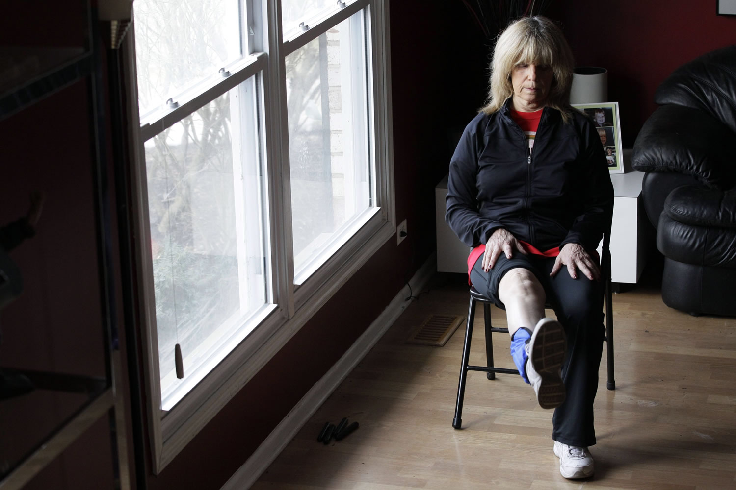 In this Feb. 4, 2012 photo, Donna Brent, 63, works out her leg at her home in Deerfield, Ill. Brent says decades of racket ball, tennis, softball and other sports took a toll on her knees, but she got used to living with the pain, even when she became bowlegged and developed a limp. When pain started getting in the way of some of her sports, she gave in to her doctor's advice and had a knee replacement operation last June on her right knee. Nearly 1 in 20 Americans older than 50 have bionic knees, or more than 4 million people, according to the first national estimate showing how common these replacement joints have become in an aging population. (AP Photo/Nam Y.