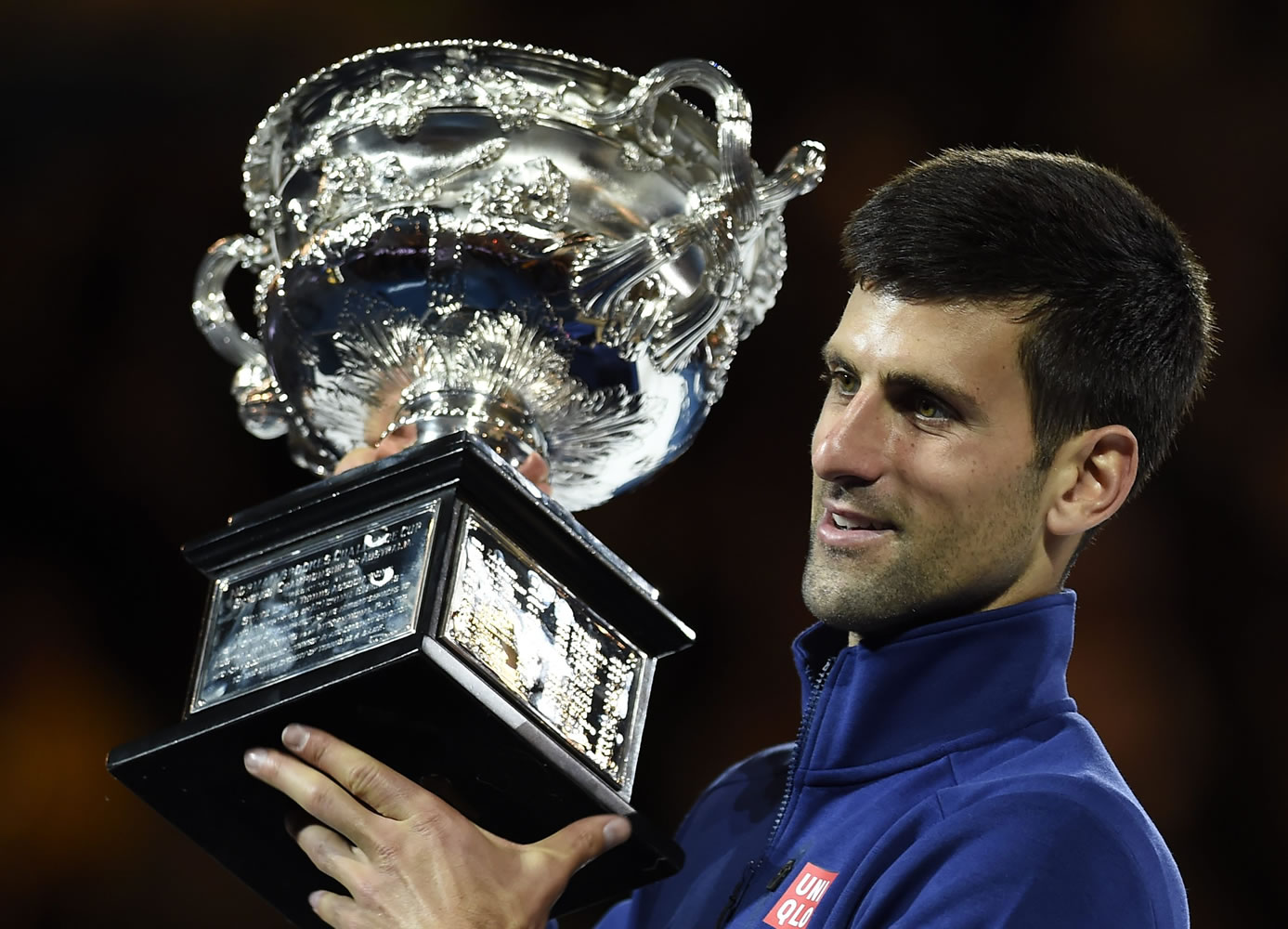 Novak Djokovic of Serbia holds his trophy aloft after defeating Andy Murray of Britain in the men's singles final at the Australian Open tennis championships in Melbourne, Australia, Sunday, Jan.