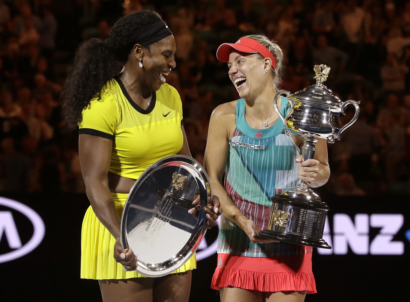 Angelique Kerber, right,  of Germany holds the trophy with runner-up Serena Williams of the United States after winning their women's singles final at the Australian Open tennis championships in Melbourne, Australia, Saturday, Jan. 30, 2016.