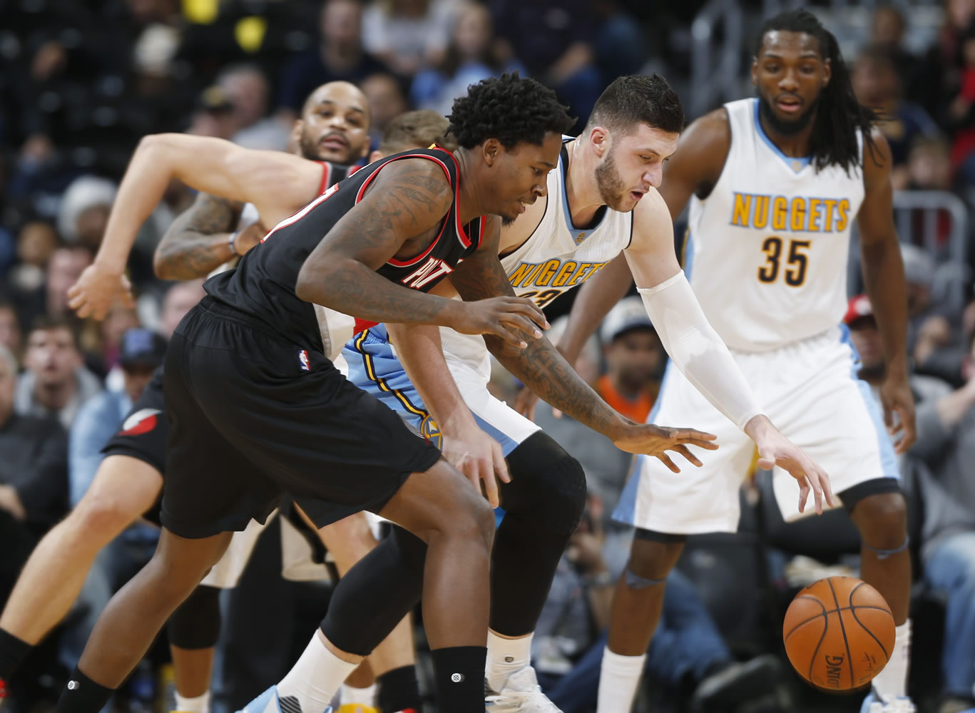 Portland Trail Blazers center Ed Davis, front, pursues the ball with Denver Nuggets center Jusuf Nurkic, center and forward Kenneth Faried in second half of an NBA basketball game Sunday, Jan. 3, 2016, in Denver. Portland won 112-106.