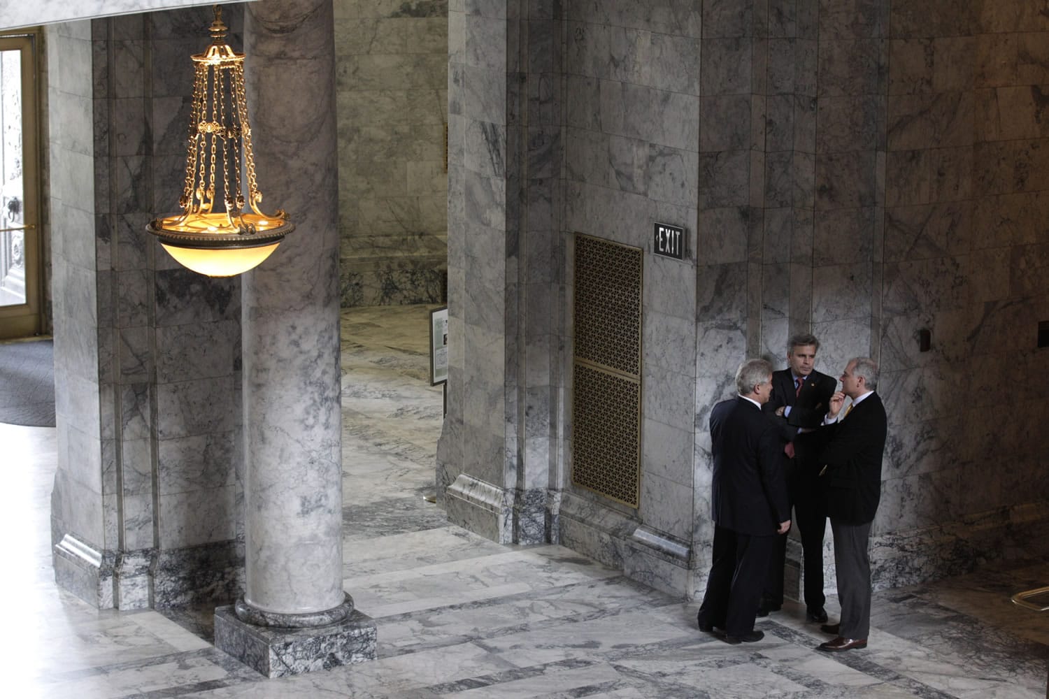 Rep. Glenn Anderson, R-Fall City, left, Sen. Steve Litzow, R-Mercer Island, center, and Rep. Reuven Carlyle, D-Seattle, right, confer in a hallway near Gov. Chris Gregoire's office, Tuesday during ongoing budget negotiations at the Capitol in Olympia, Wash.