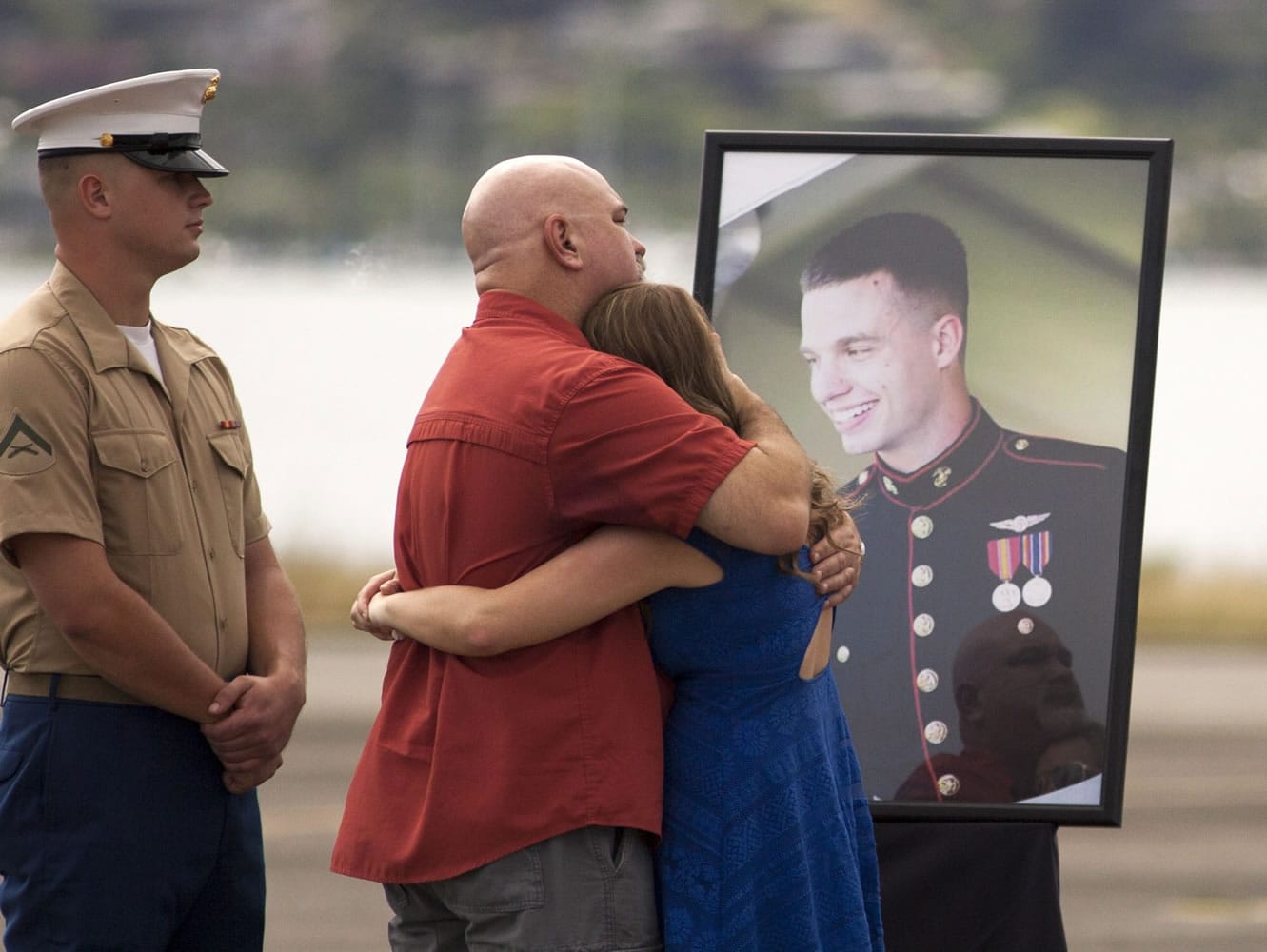 Unidentified family members gather around a photo of Lance Cpl. Ty L. Hart, 21, of Aumsville, Ore., during a memorial service Friday at Marine Corps Base Hawaii in Kaneohe, Hawaii, for the 12 Marines who died in a helicopter crash off of Oahu on Jan. 14.
