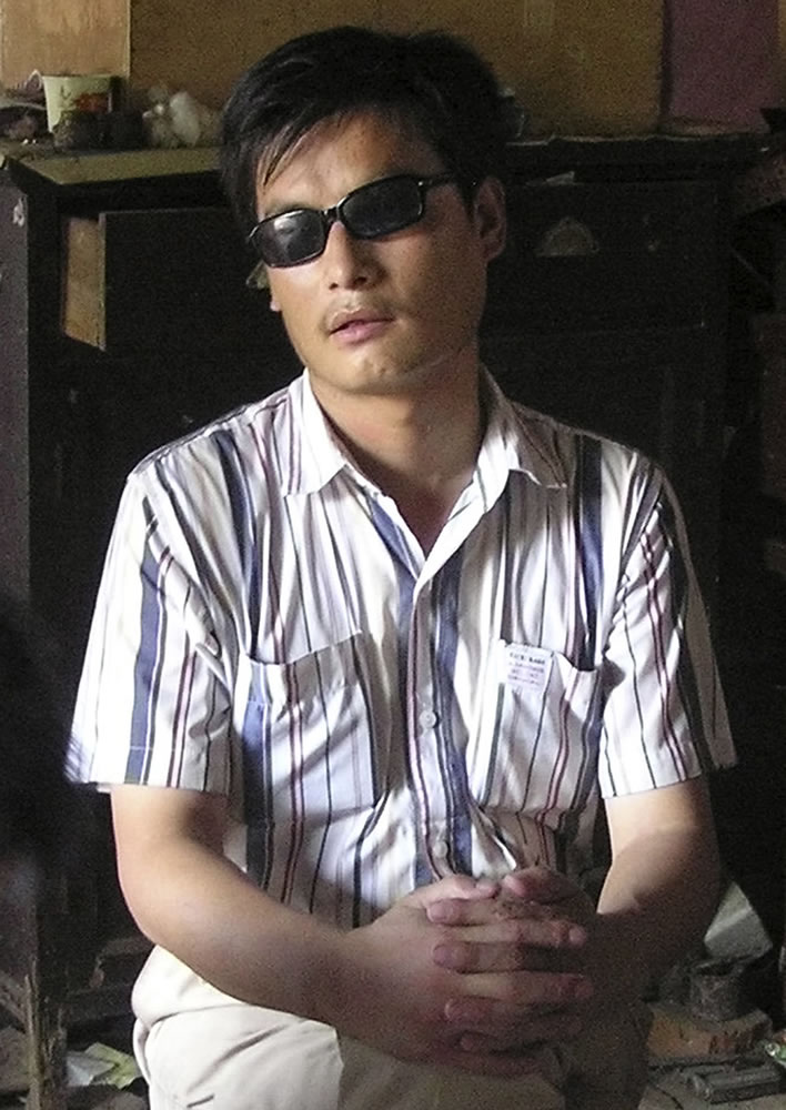 FILE - In this undated file photo released by his supporters, blind activist Chen Guangcheng sits in a village in China. Rights campaigners said Friday, April 27, 2012 that Chen, a leading figure in China's rights movement, escaped the house arrest he lived under for 18 months in Shandong province this week.