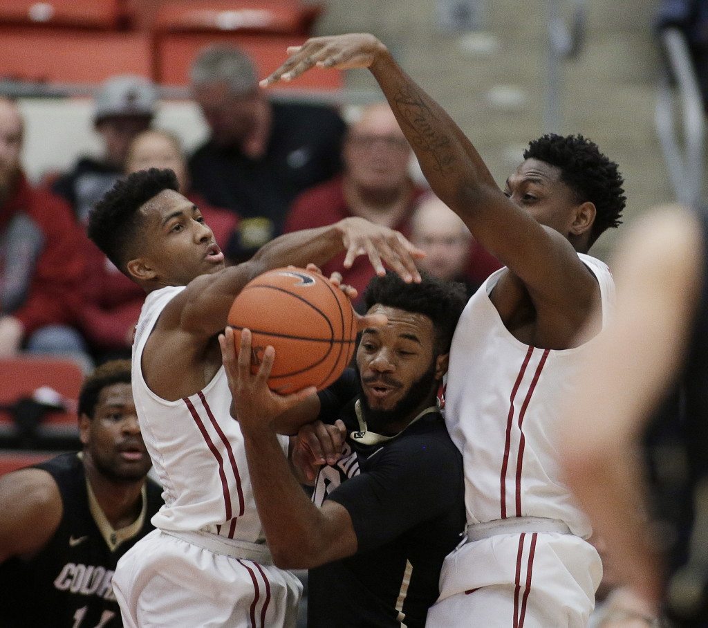Colorado's Tre'Shaun Fletcher, center, goes after a rebound against Washington State's Ny Redding, left, and Robert Franks during the first half of an NCAA college basketball game Saturday, Jan. 23, 2016, in Pullman, Wash.