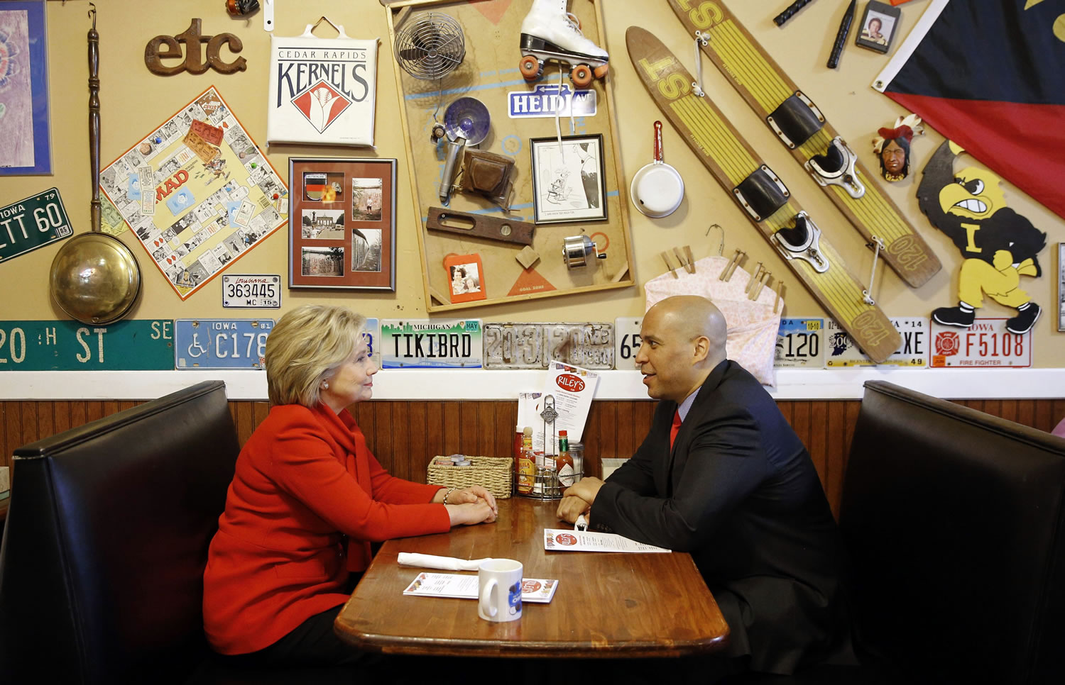 Democratic presidential candidate Hillary Clinton, left, chats with Sen. Cory Booker, D-N.J., Sunday at Riley&#039;s Cafe in Cedar Rapids, Iowa.