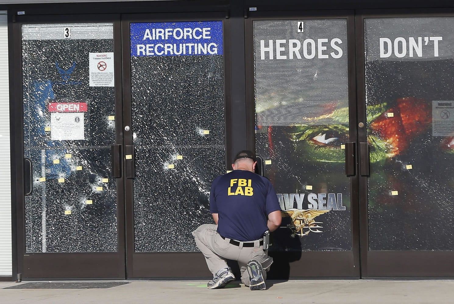 FILE - In this July 17, 2015, file photo, an FBI investigator investigates the scene of a shooting outside a military recruiting center in Chattanooga, Tenn. Violent crime rose across in the country in the first six months of 2015 compared to the same period the year before, according to preliminary data released Tuesday,Jan. 19, 2016, by the FBI.
