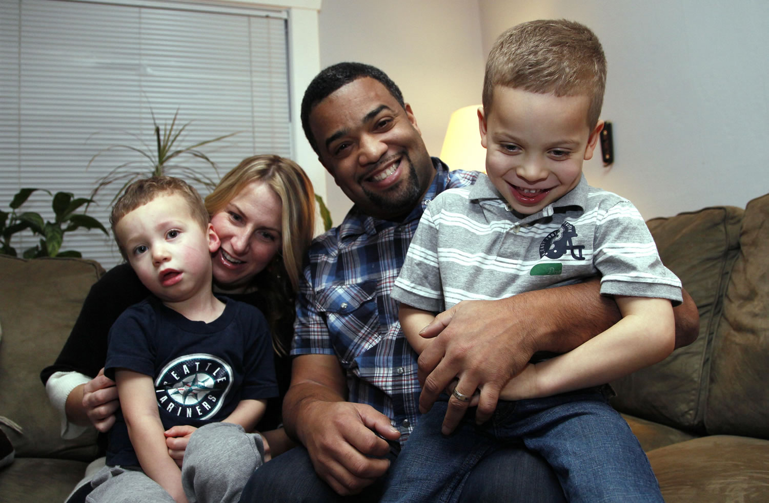 Damon Brown and his wife, Bethany, hold their sons Theo, 3, left, and Julian, 5, at their home in Seattle.