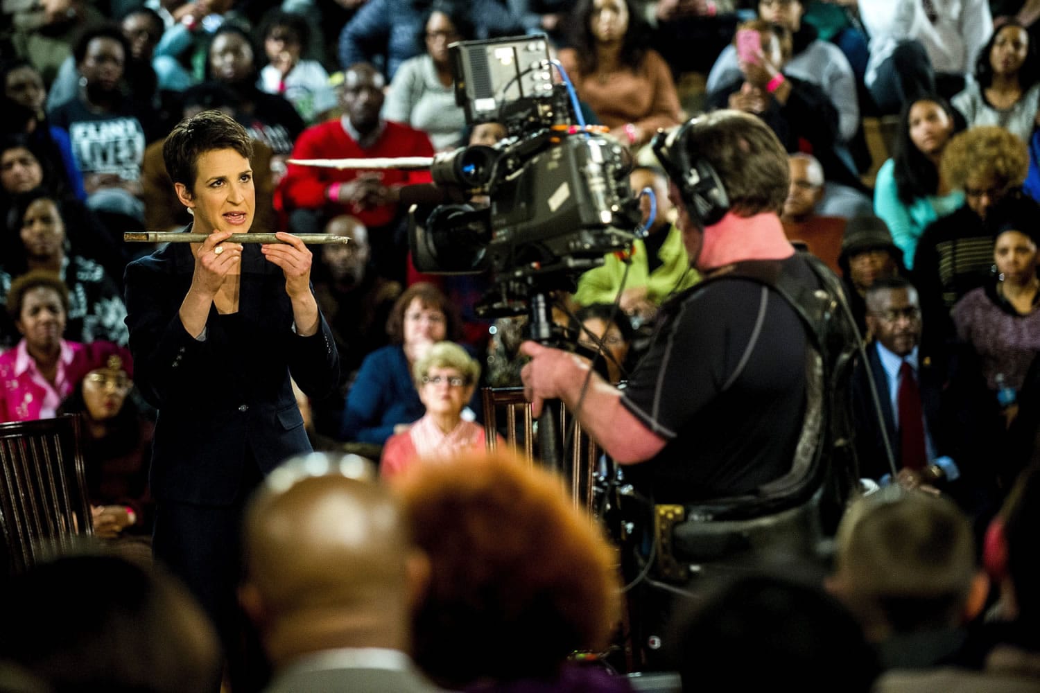 MSNBC&#039;s Rachel Maddow shows an example of a piece of galvanized pipe, which was cut out of the wall from Flint resident Harold Harrington&#039;s home during a television broadcast on Wednesday at Holmes STEM Academy in Flint, Mich.