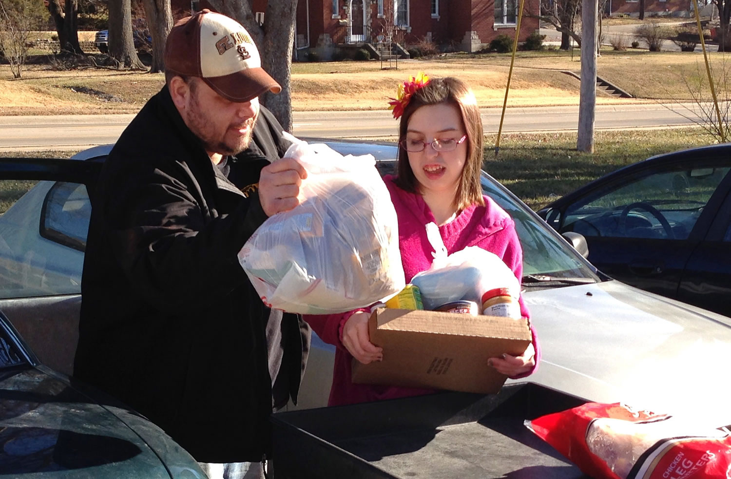In this Jan. 28, 2016 photo, Joe Heflin, left, of Jefferson City, loads free groceries into the backseat of his car with the help from a volunteer at the Samaritan Center food pantry in Jefferson City, Mo.  Heflin, 33, also receives federally funded food stamp benefits. He is among the more than 1 million people nationwide whose food stamps could end in three months if he doesnt meet work requirements or receive a disability exemption. (AP Photo/David A.