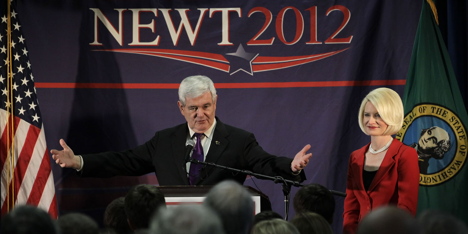 Republican presidential candidate, former House Speaker Newt Gingrich speaks as his wife, Callista Gingrich, looks on during a campaign stop at a hotel Friday in Federal Way.