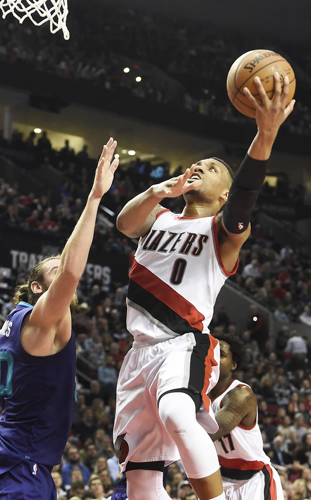 Portland&#039;s Damian Lillard (0) drives to the basket on Charlotte&#039;s Spencer Hawes during the second half of Friday&#039;s game. Lillard scored 22 points to go with five rebounds and six assists in the Blazers&#039; 109-91 win.