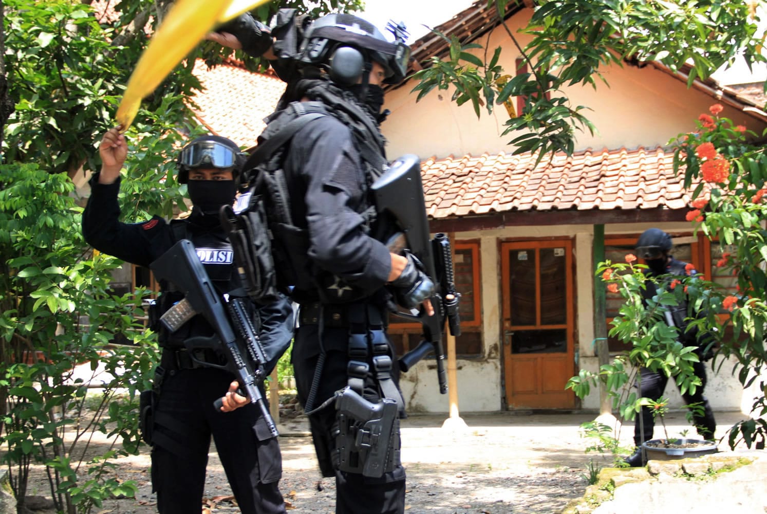 Officers of Indonesian police&#039;s anti terror unit stand guard outside the house of a suspected militant following a raid in Cirebon, West Java, Indonesia, on Friday.