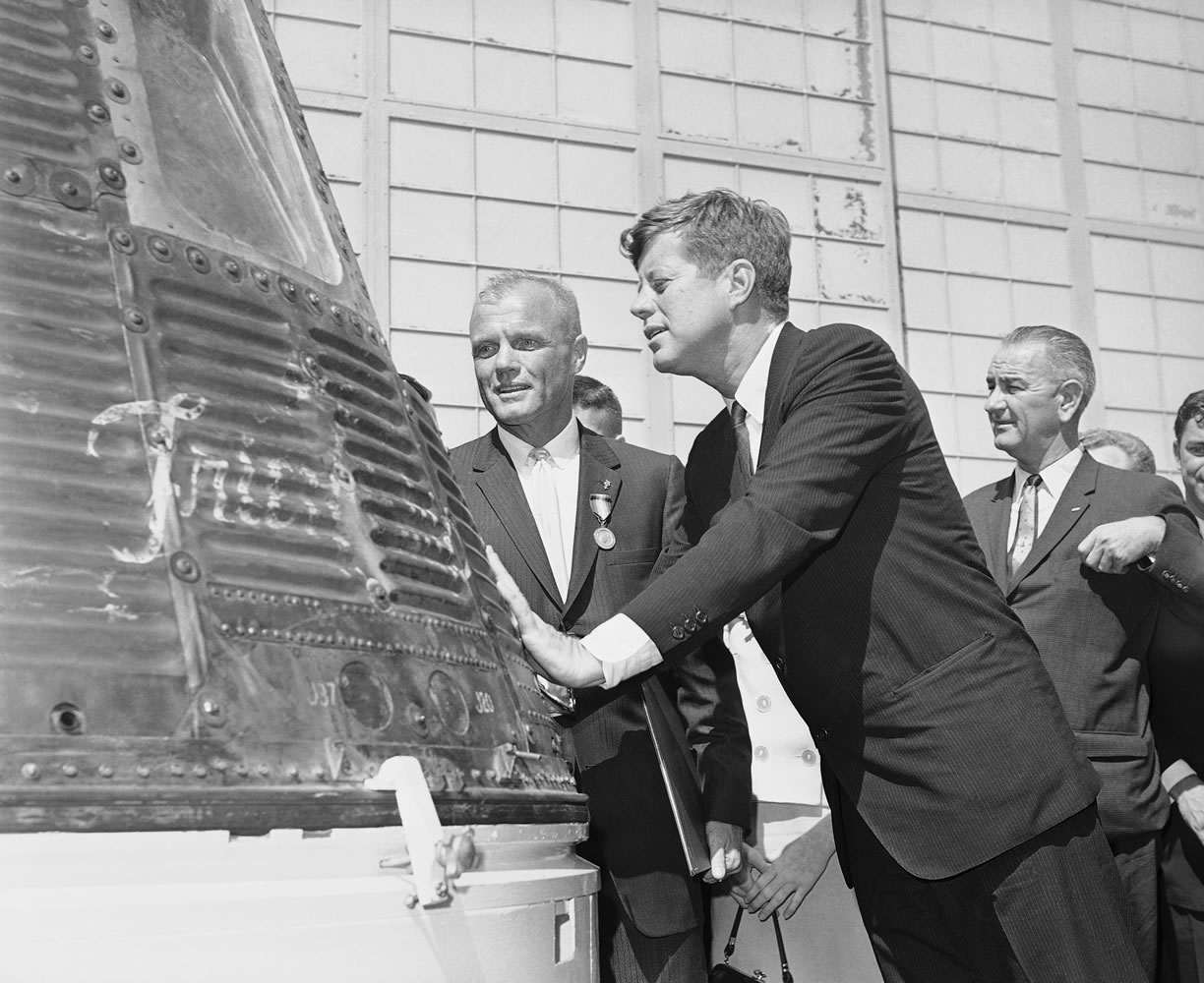 In this Feb. 23, 1962 file photo, astronaut John Glenn, left, and President John F. Kennedy, center, inspect the Friendship 7 Mercury capsule which Glenn rode in orbit. At right is Vice President Lyndon B. Johnson.